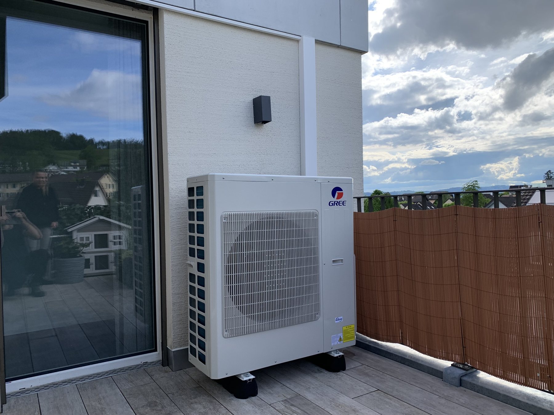 Gree-Aussengerät auf einer Terrasse mit Sichtschutz