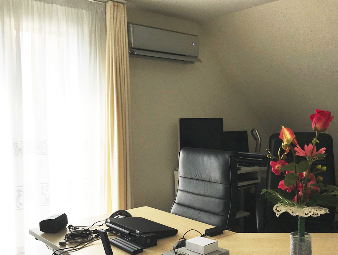 Klimagerät an der Wand eines Büros mit Schreibtisch