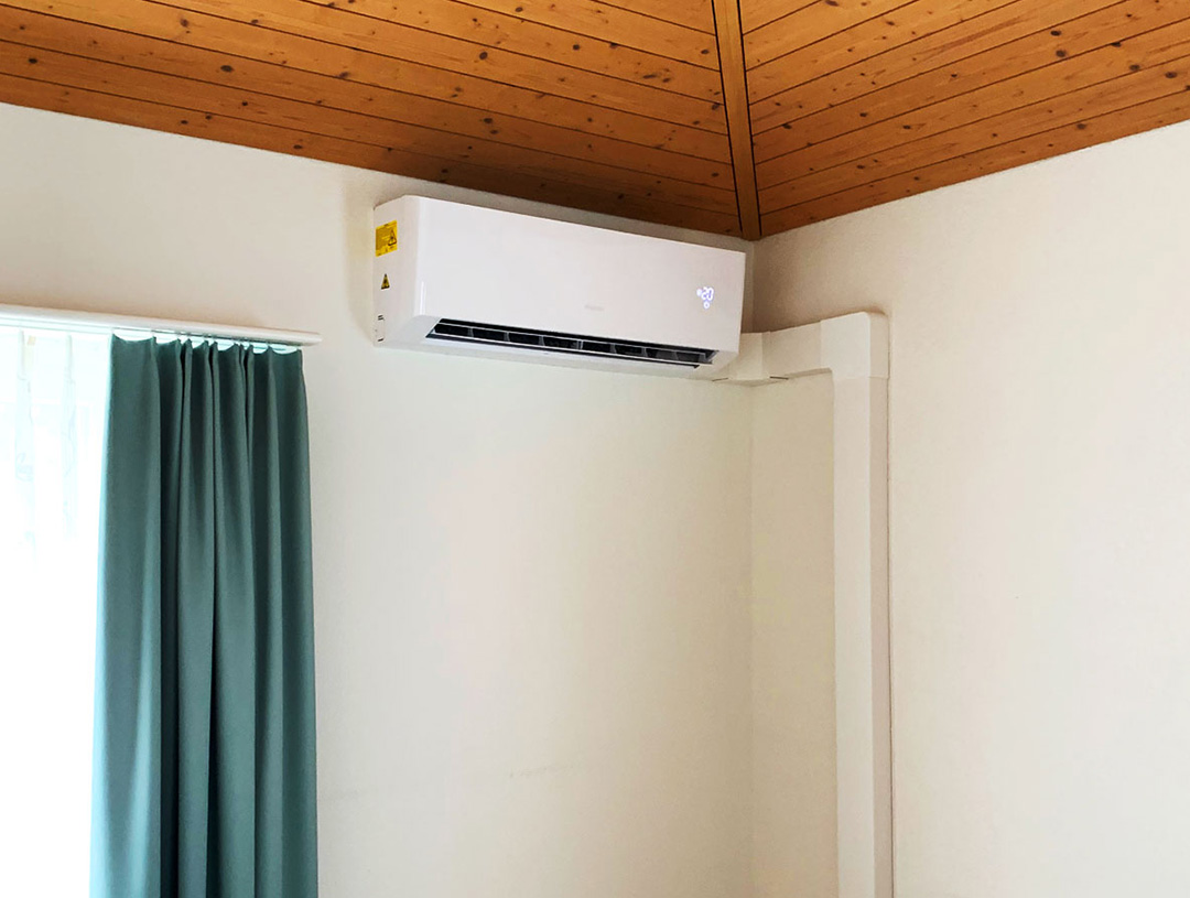 Weisses Wandgerät im Schlafzimmer unter einer Holzdecke