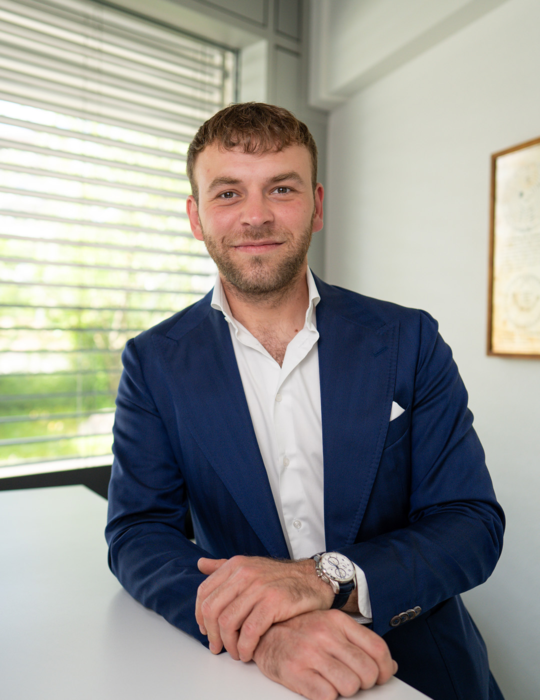 Lavdim Alimi, Inhaber der L. Alimi GmbH, im Sakko am Tisch